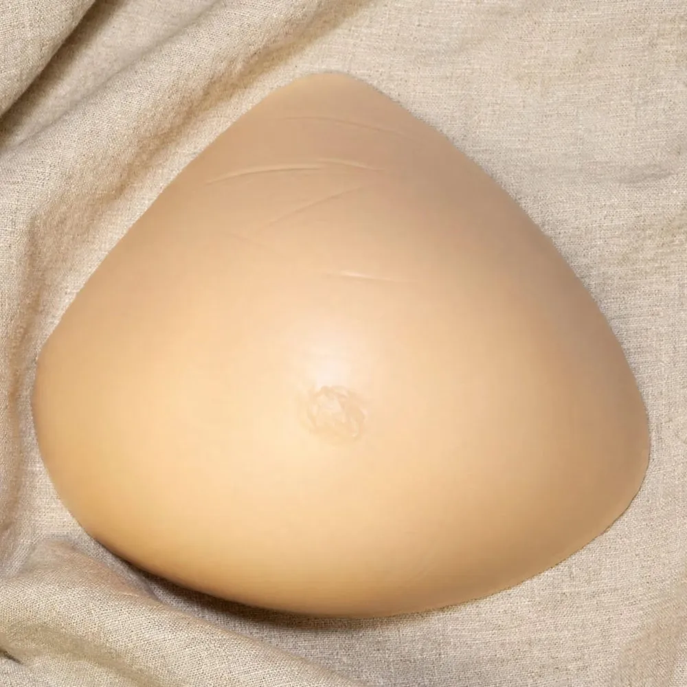 A lightweight silicone breast form resting on linen fabric