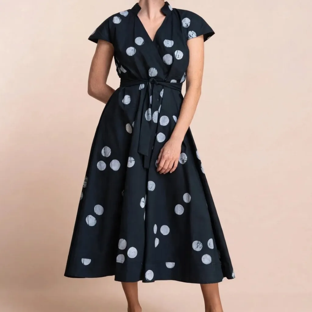 A navy polka-dot wrap dress with a tie waist